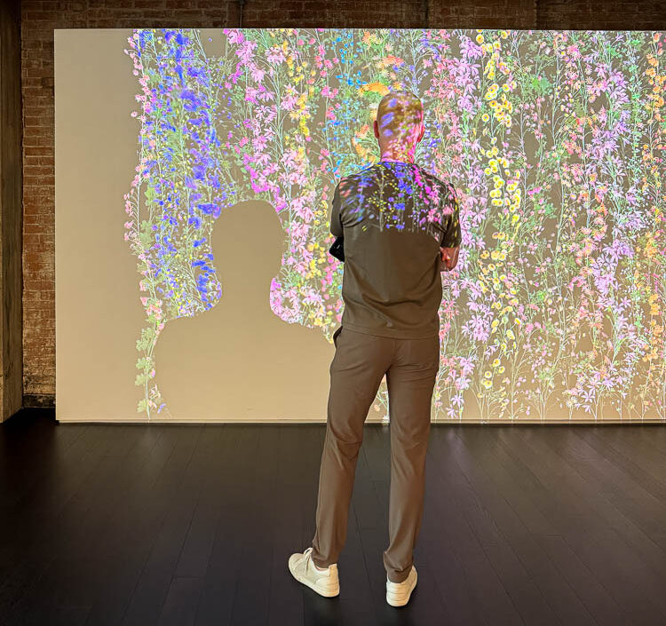 Where Interior Designers Find Inspiration: a Yates Desygn team member interacting with a digital art installation at the Thoma Foundation in Dallas